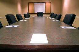 empty board room table with pens and paper