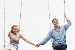 Couple Holding Hands on Swing Set