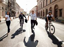 Businesspeople competing with bicycles and running in the city