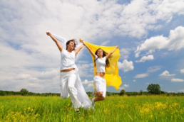 women skipping through grass