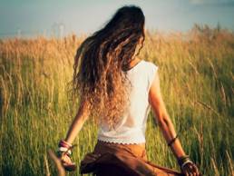 woman walking through a field at sunset featured