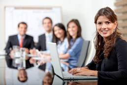 Senior board level woman on laptop in meeting