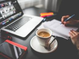 Flexible working, Woman writing in notepad, Laptop on desk featured