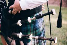 man playing bagpipes in kilt burn's night featured