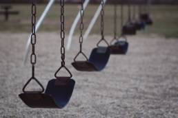 A set of empty black swings in a line