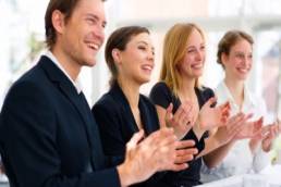 team clapping together and looking happy featured