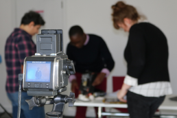 camera pictured with group of people out of focus, same but different project featured