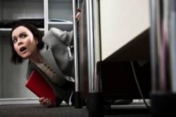 competitive workplace woman looking scared featured