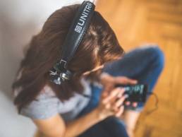 woman listening to music on her phone featured