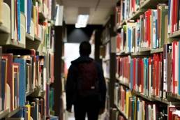 person standing in a library featured