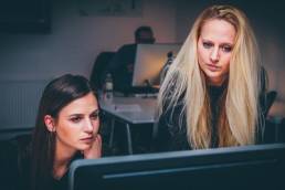 two friends colleague sitting next to each other featured
