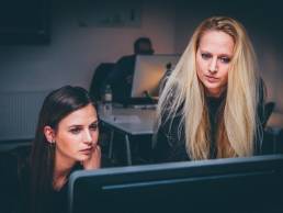 two friends colleague sitting next to each other featured