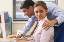 man sexually harassing woman at work featured