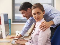 man sexually harassing woman at work featured