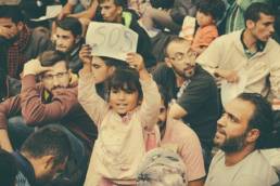 refugees huddled together at train station featured