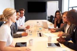 group of people meeting in a boardroom featured