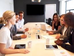 group of people meeting in a boardroom featured