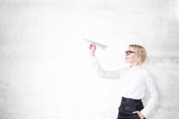 woman-flying-a-paper-airplane-featured