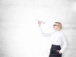 woman-flying-a-paper-airplane-featured