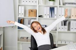 Female Entrepreneur in her office and smiling with arms outstretched