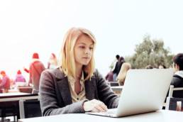 young attractive woman at her laptop searching for jobs
