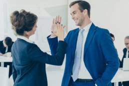 colleagues giving an office high-five featured