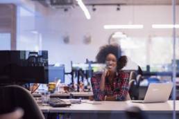 black business woman sitting at her desk featured