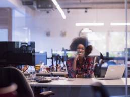 black business woman sitting at her desk featured