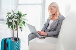 female traveller, women on laptop at airport, travel featured