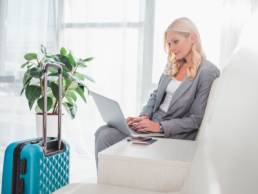 female traveller, women on laptop at airport, travel featured