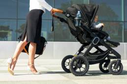 Business mother pushing baby on the way to work, working mum