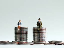 man and woman sitting on coins, equality