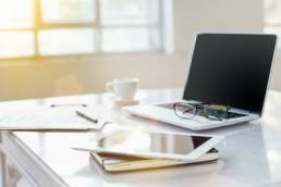 The tipical office desktop with pc, pens, notebook, laptop