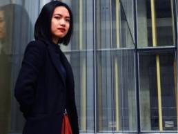 asian woman standing outside her work, returning to work 1