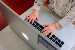 baby typing on a laptop, single parent business owner, entrepreneur