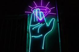 neon sign, hand holding a diamond