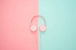 pink headphones on background, wearing headphones at work