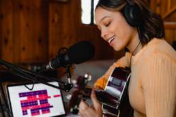 black woman playing guitar, music studio, music industry