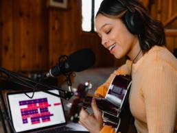 black woman playing guitar, music studio, music industry