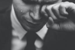 man wiping away tear, grief, bereavement