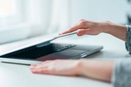 Close-up image of female hands open or close laptop on white table, work-life balance, working from home