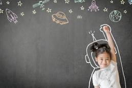 Kid's learning inspiration world in science education with girl child's imagination doodle on teacher's school chalkboard for back to school month and international or universal children's day concep