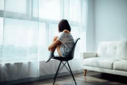 woman sat on a chair in the middle of the room, anxierty, mental health
