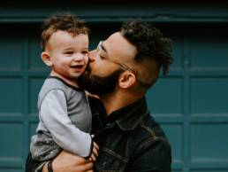 Dad carrying and kissing his son, parenting