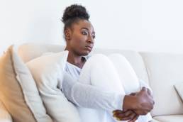 Domestic abuse survivor, sad woman sitting on couch, domestic abuse victim