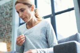 menopause, mature woman touching sweater and having hot flash