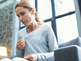 menopause, mature woman touching sweater and having hot flash