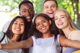 Cheerful international friends teenagers taking selfie while walking in summer park, young generation