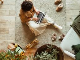 Christmas : New Year decorated home living room. Beautiful woman working on laptop, switching off this Christmas