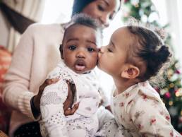 Little Girl Kissing her Baby Cousin, Refuge Christmas campaign